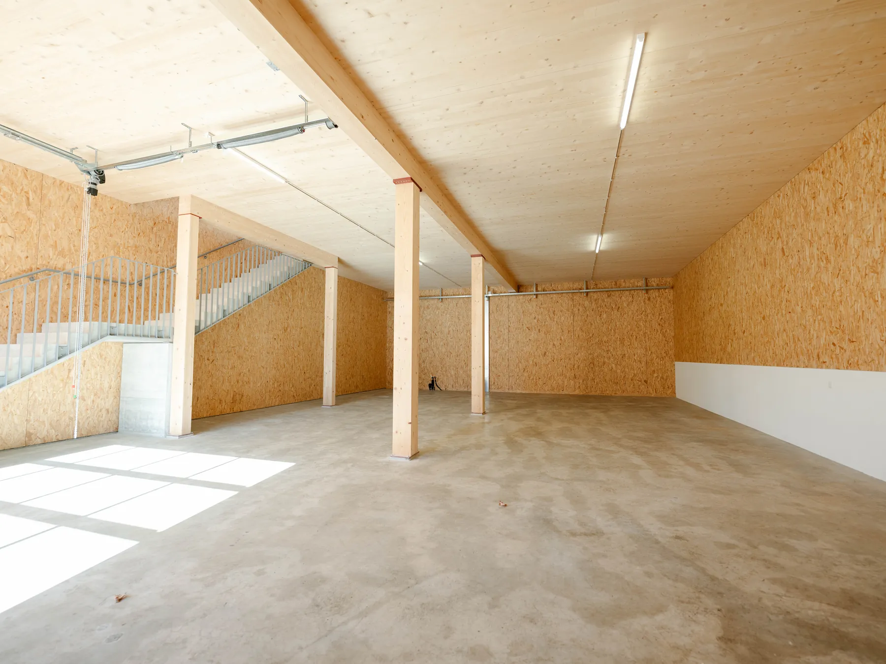 Erdgeschoss mit Monobetonboden, Holzstützen und Treppe
