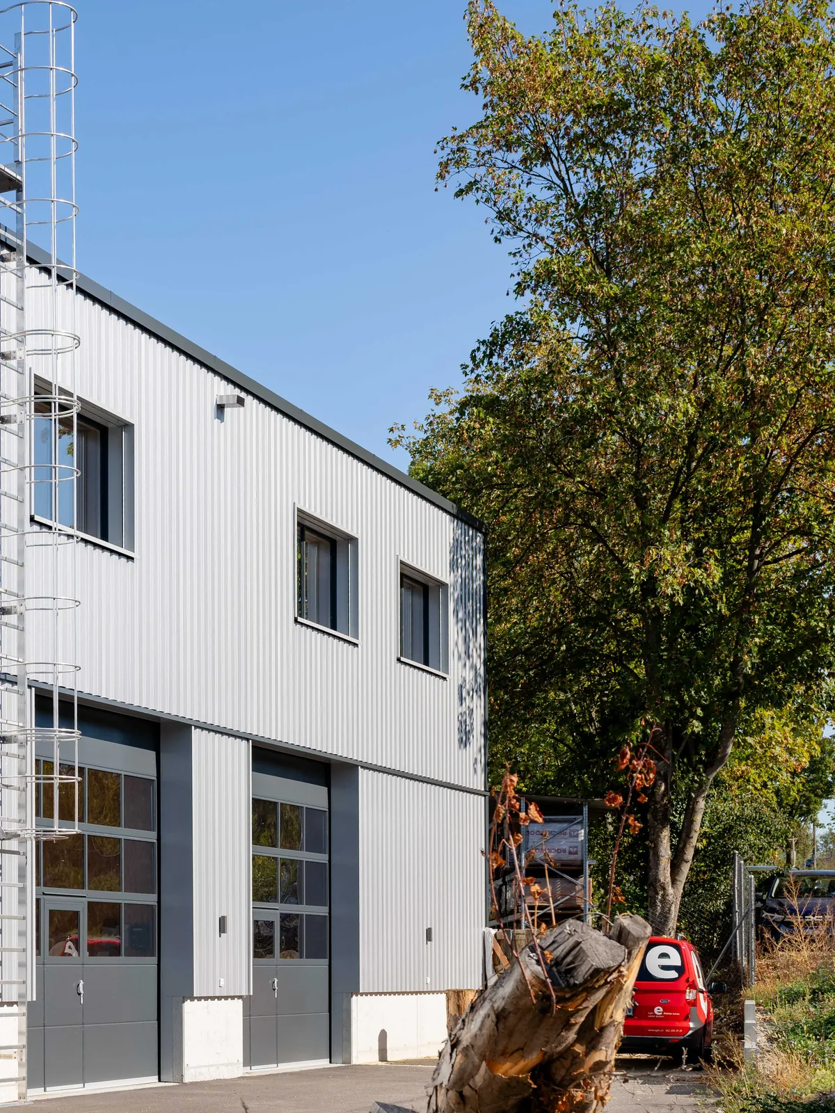 Profilblech-Fassade mit Fenstern, Steigleiter und Sektionaltoren