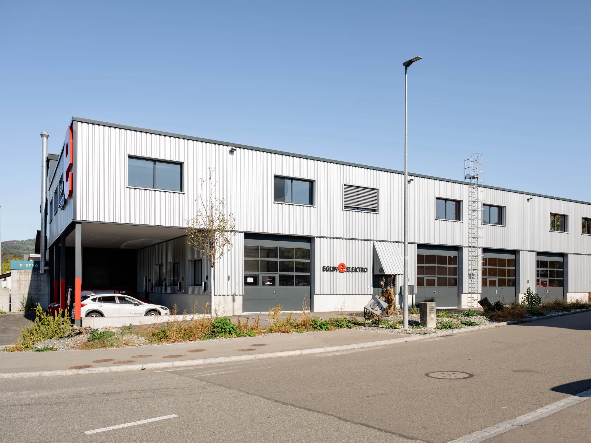 Kopfbau des Neubaus mit Betonsockel und Profilblech-Fassade