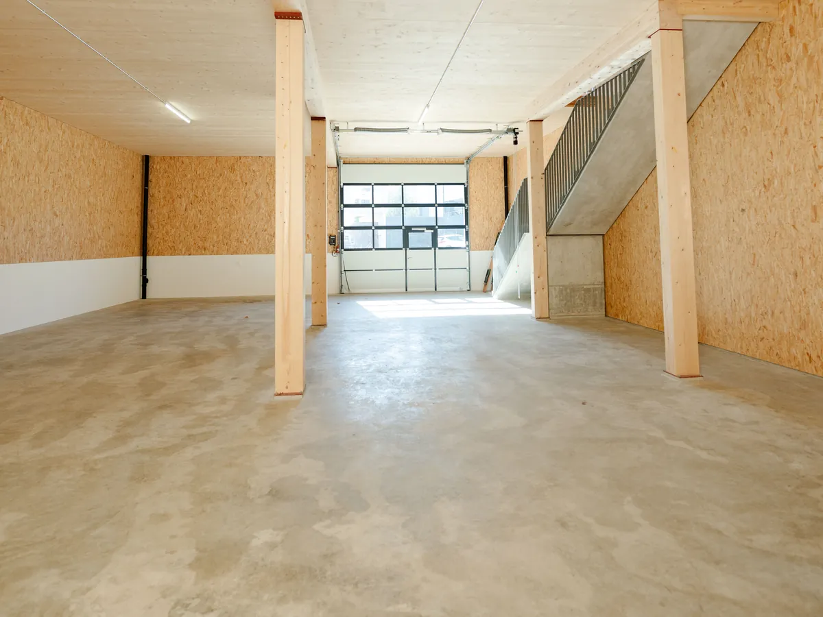 Monobetonboden mit Holzstützen und Sektionaltor im Erdgeschoss
